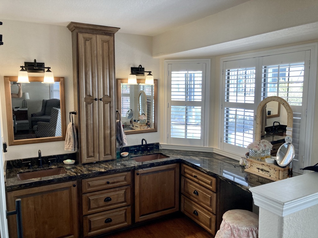 Bathroom with wood cabinetry and a dual vanity