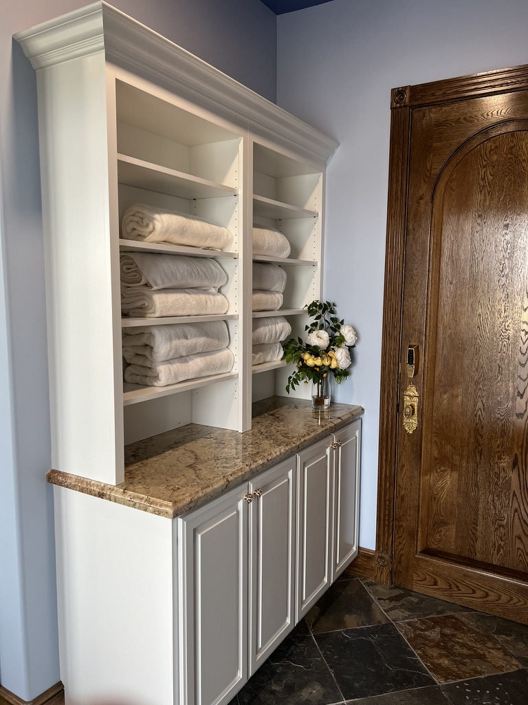 Custom linen cabinetry with stone countertop