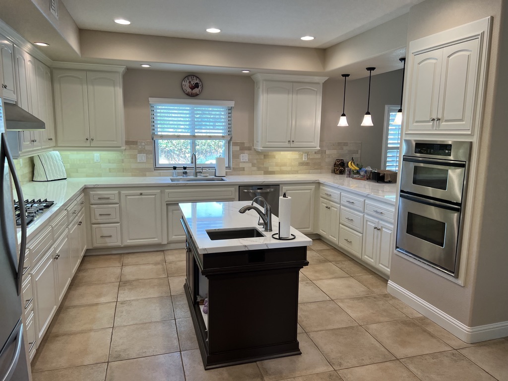 White kitchen remodel with a large central island and pendant lighting
